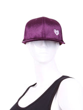 Load image into Gallery viewer, The Purple Velvet Tennis Hat exudes a unique blend of elegance and sporty charm. Crafted from a plush and rich purple velvet material, this hat sets itself apart with its luxurious texture and vibrant color. The velvet fabric catches the light in a way that creates subtle shifts in hue, adding depth to the overall appearance.
