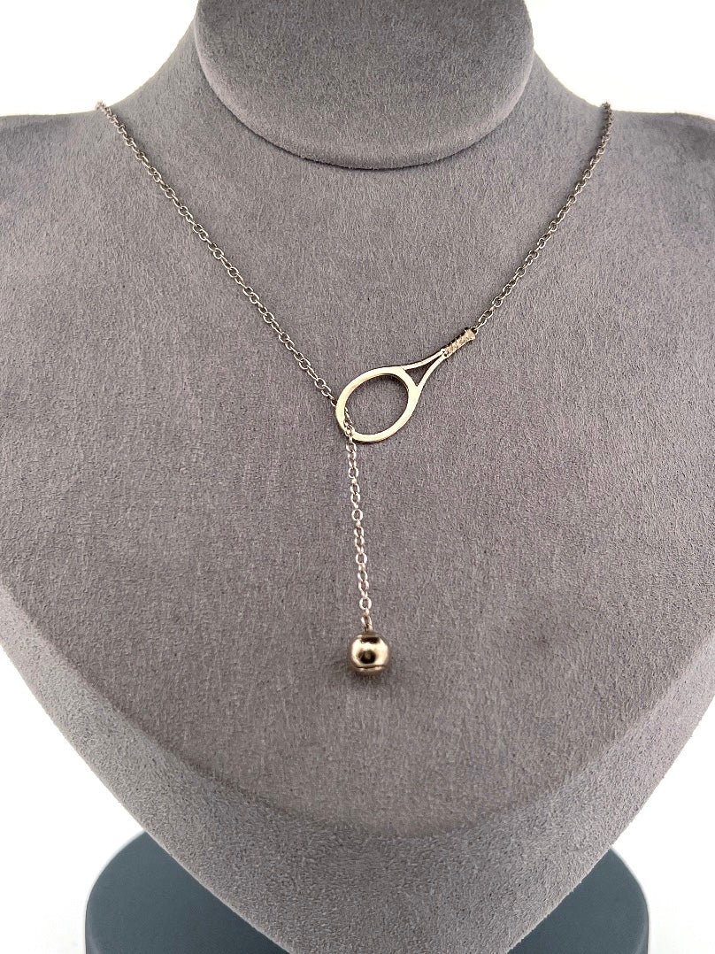 The newest design by Adeline - this unusual necklace is a tennis lovers delight.   The solid gold ball threads through the racket and can be worn higher or lower on the neck.  This piece was hand made in the jewelry district of Los Angeles by a fine jewel craft team.  The racket is 1